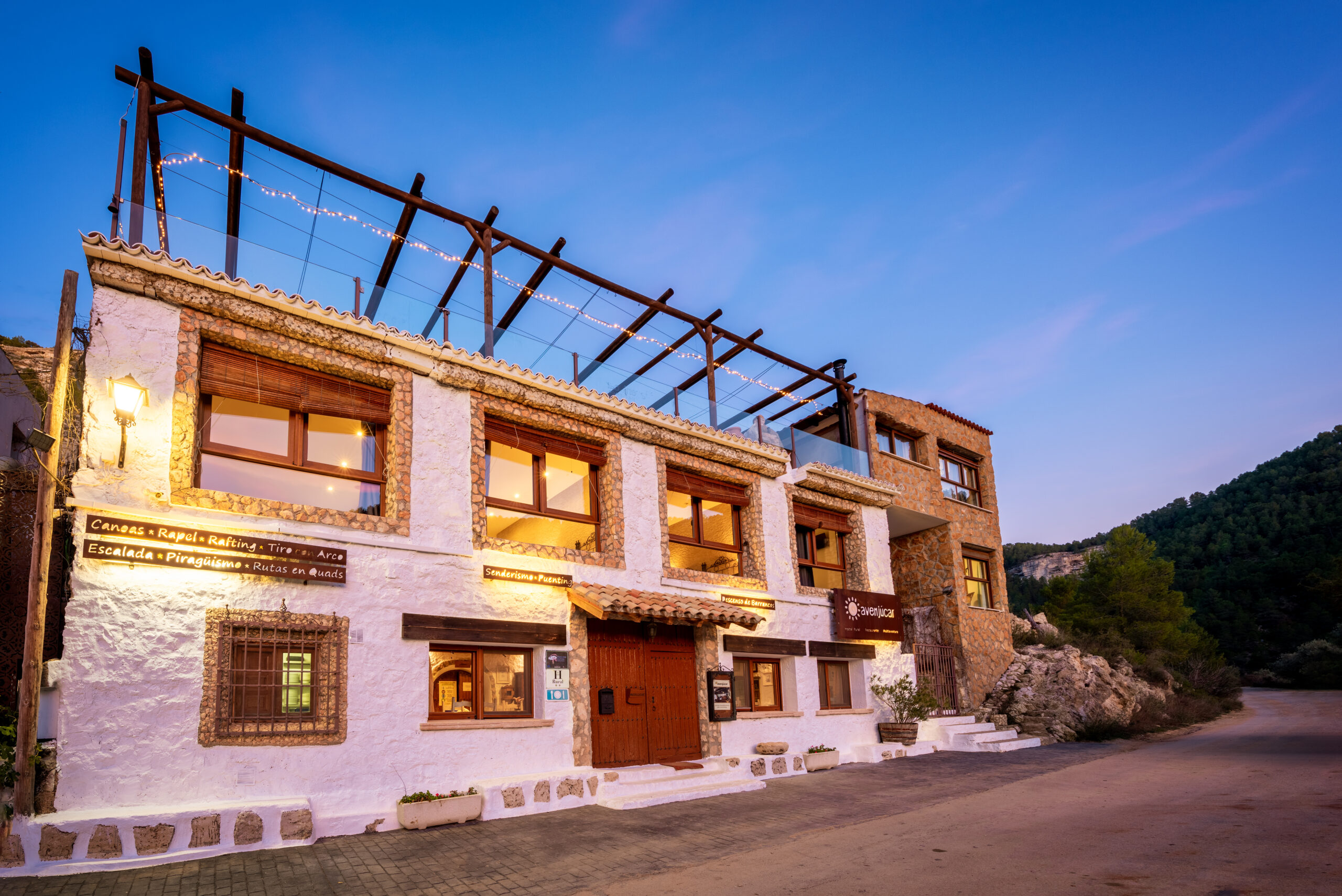 Hostal rústico al atardecer en montaña.