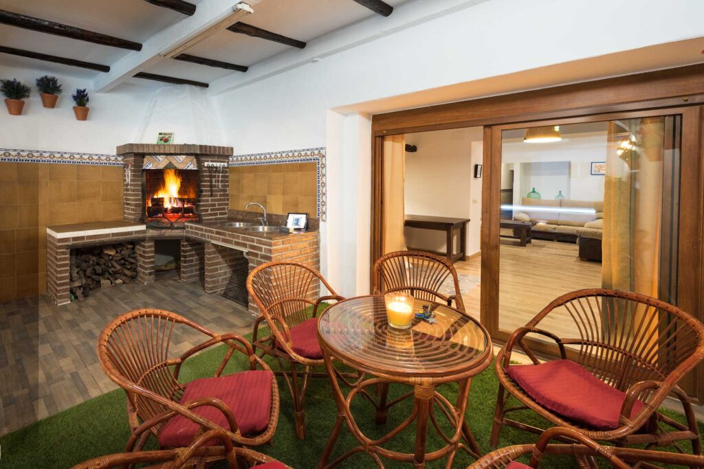 Sala rústica con chimenea y mobiliario de mimbre.