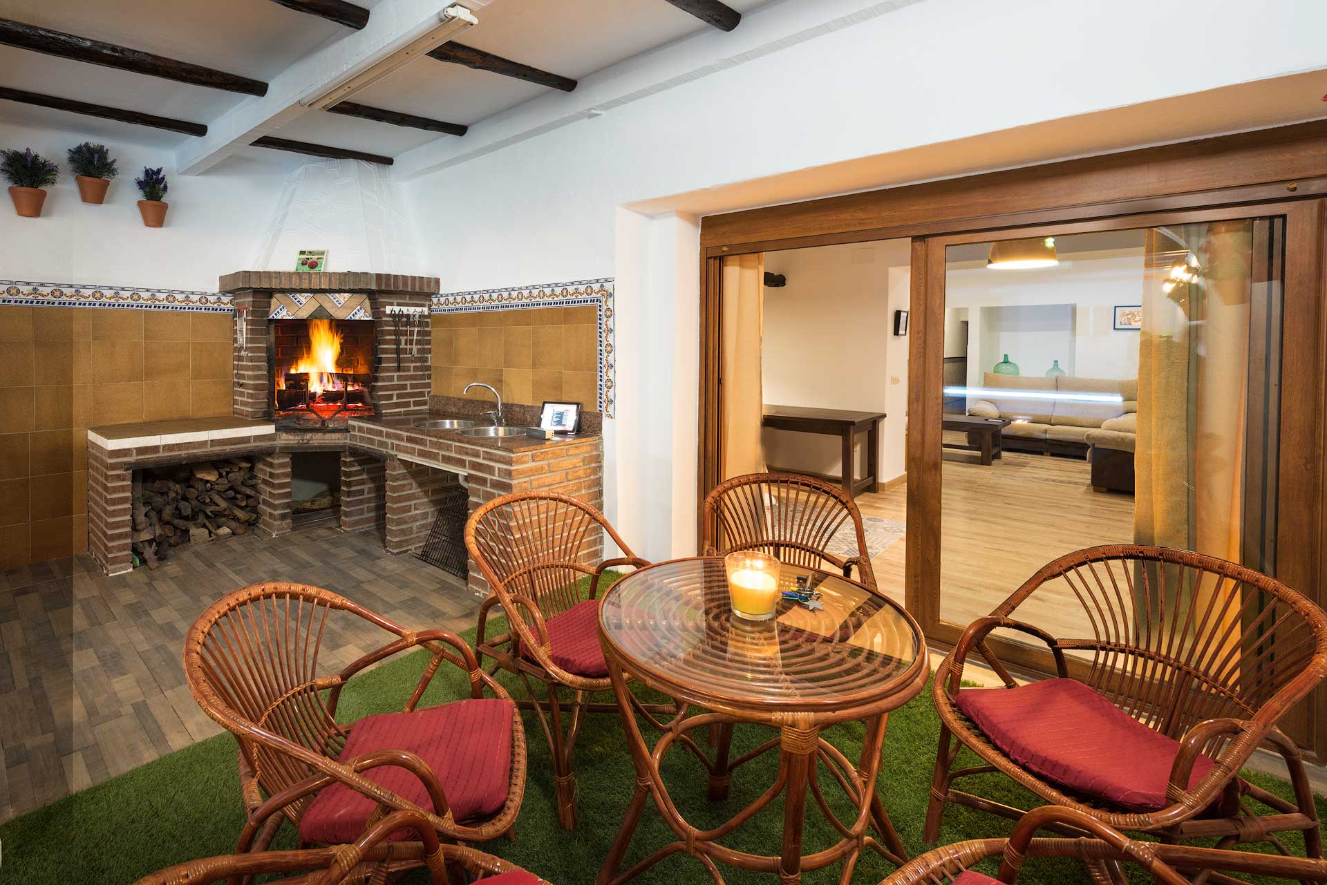 Sala rústica con chimenea y mobiliario de mimbre.