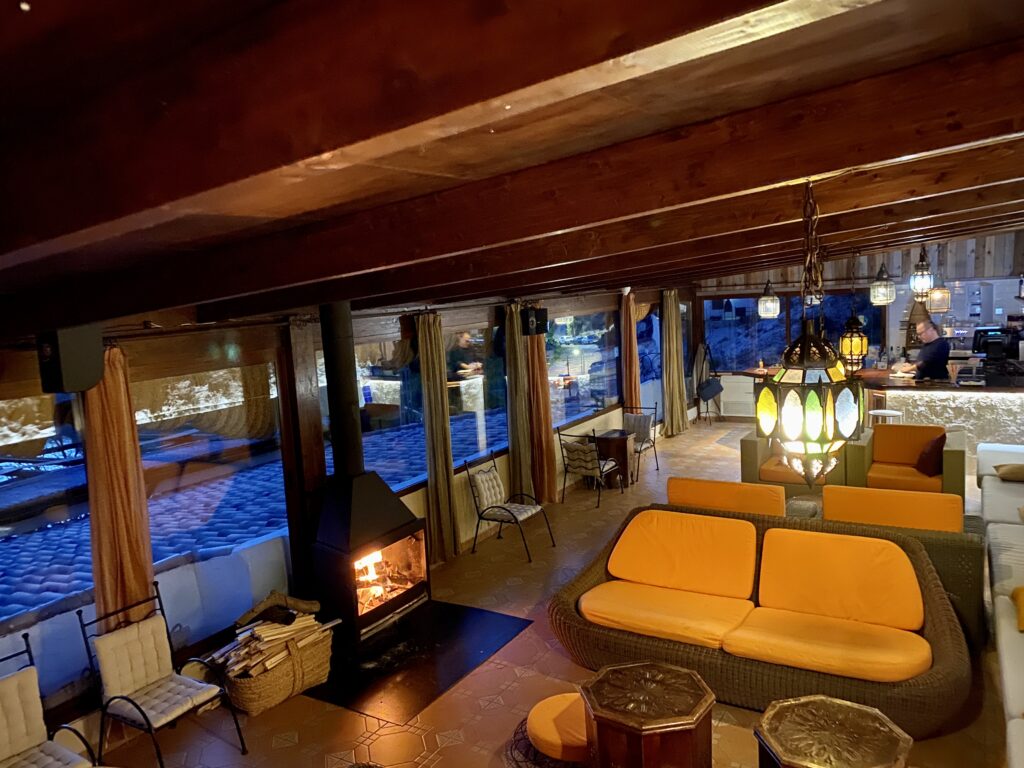 Salón acogedor con chimenea y vistas nocturnas.