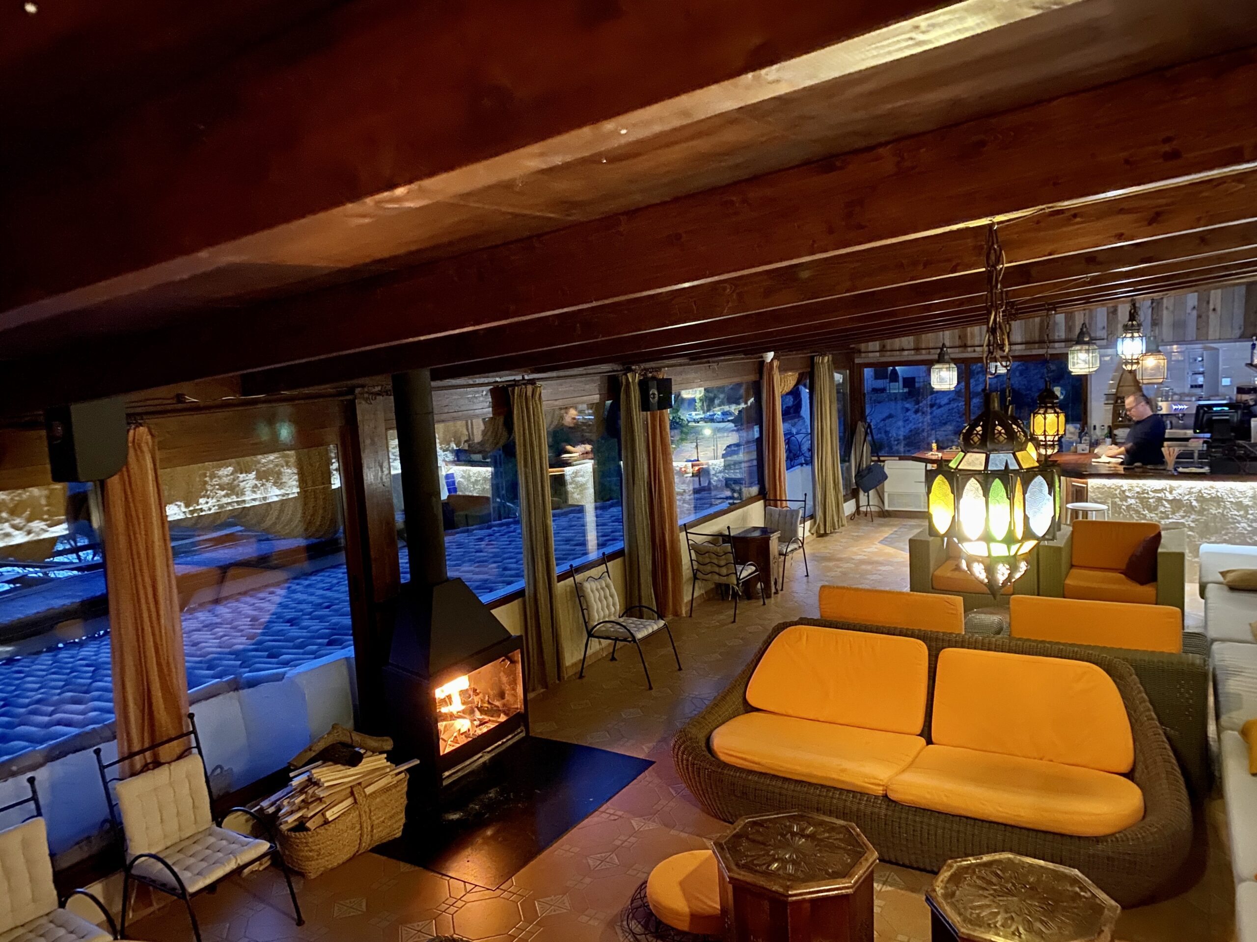 Salón acogedor con chimenea y vistas nocturnas.