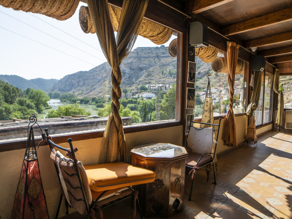 Terraza acristalada con vistas a paisaje fluvial español.
