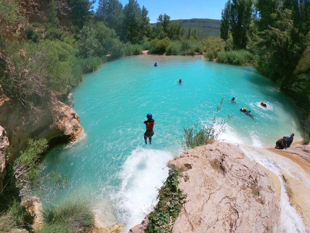 Personas nadando en laguna turquesa natural.