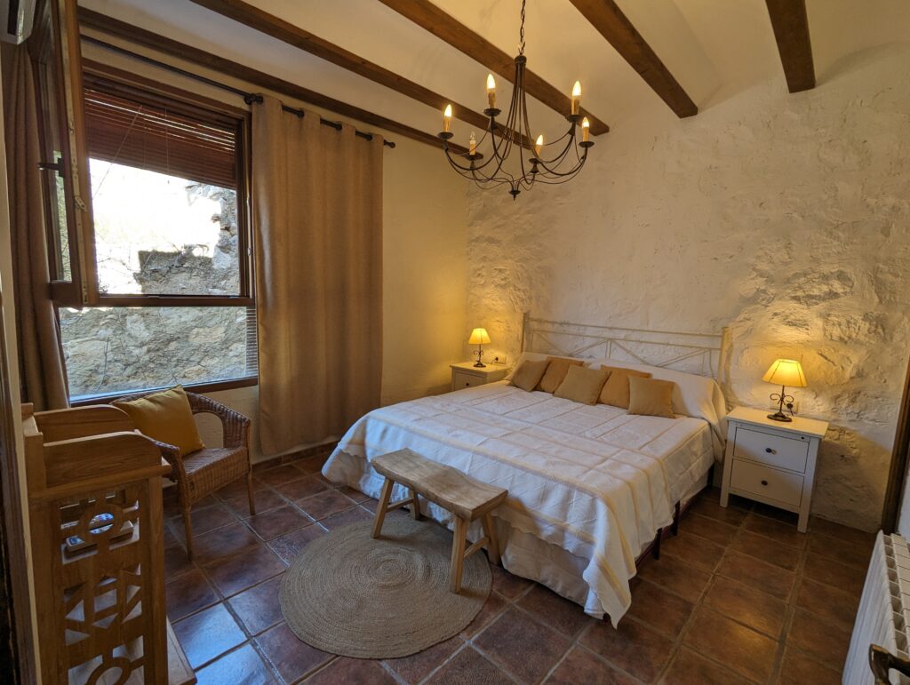 Habitación rústica con cama doble y decoración acogedora.