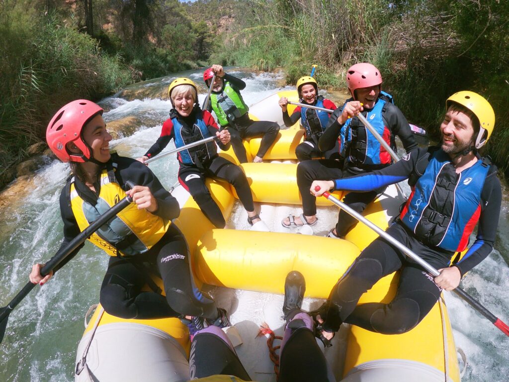 Grupo haciendo rafting en río agitado.