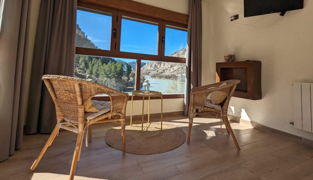 Sala de estar luminosa con vistas al lago y montañas.