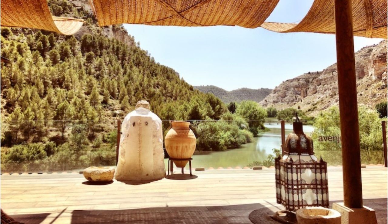 Terraza rústica con vistas al río y montañas.
